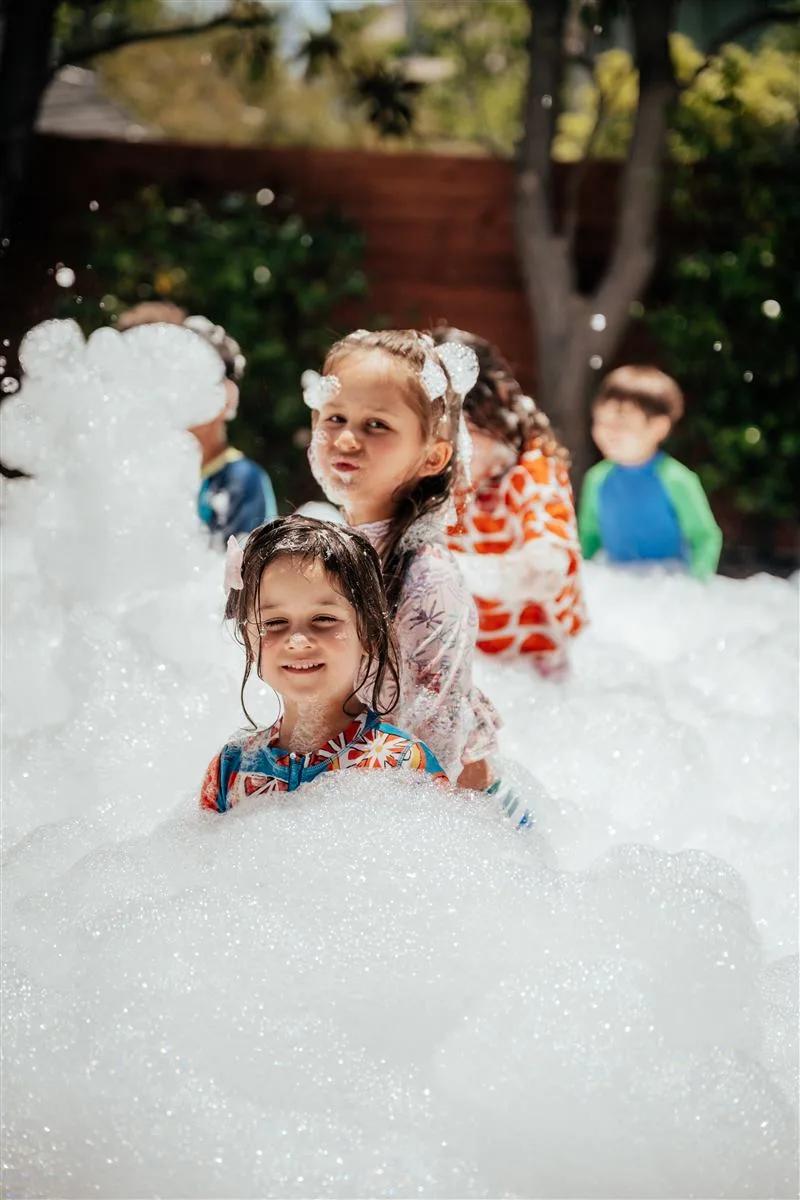 Kid covered in foam, smiling