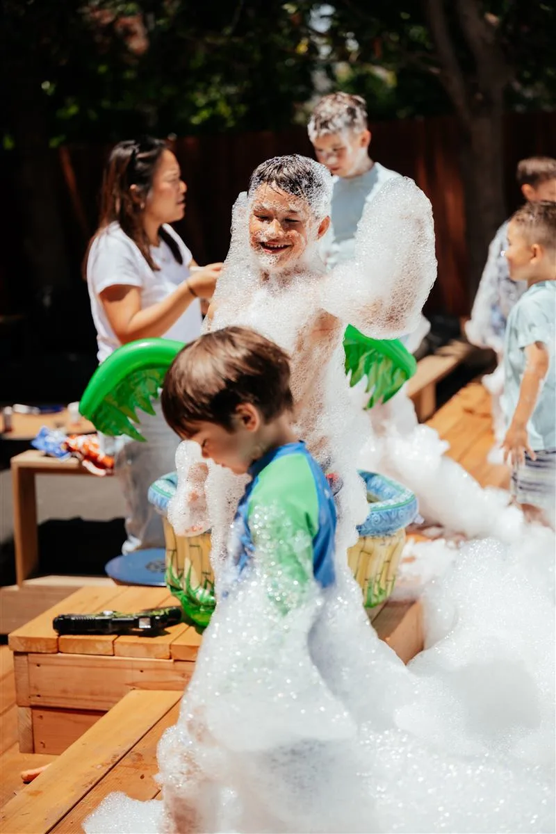 Group of kids laughing in foam party