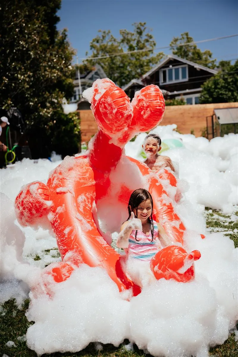 Kids having fun in the foam machine bubbles