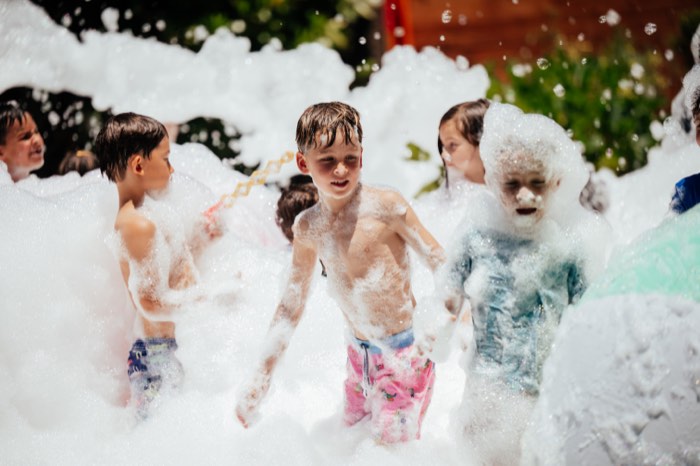 Group of kids laughing in foam party